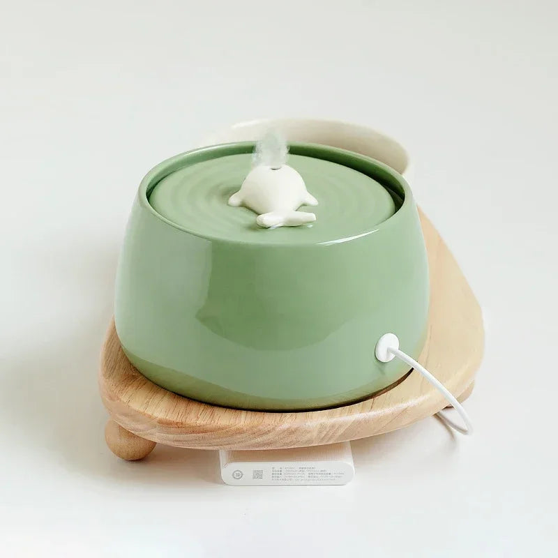 Fontaine à eau en céramique verte avec décor en forme de grenouille, base en bois, idéale pour animaux.