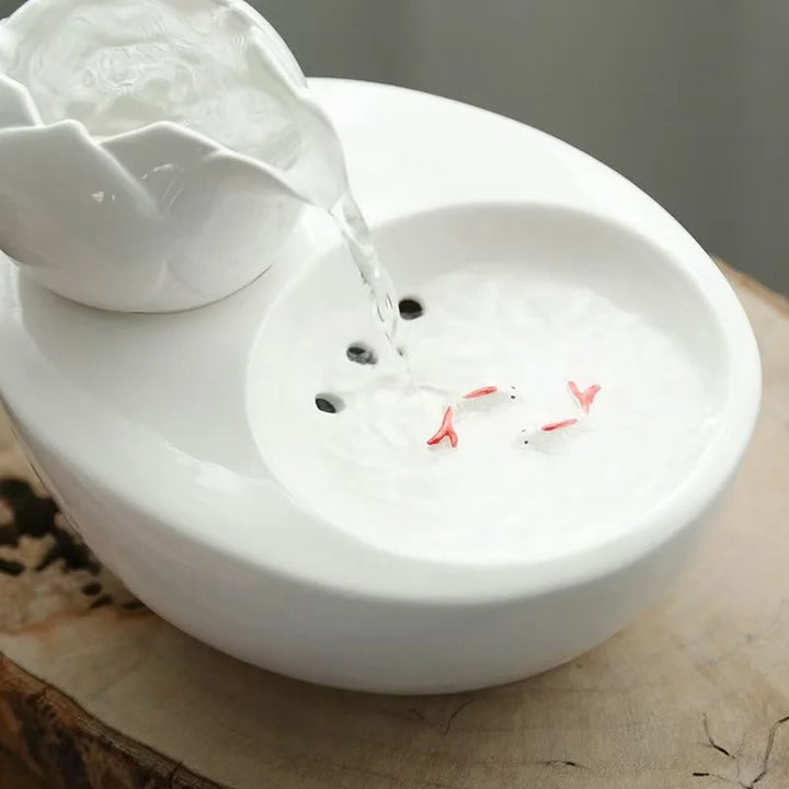 Fontaine en céramique blanche avec poissons décoratifs et arrosage apaisant, design moderne.