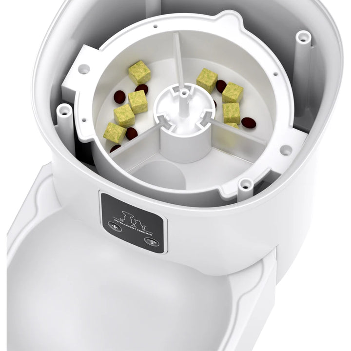 Distributeur de nourriture pour animaux, blanc, avec compartiments pour croquettes et friandises.